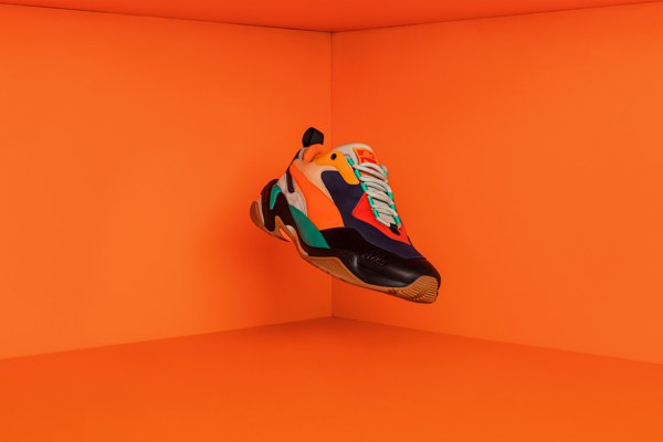 Chaussure multicolore de la collaboration, photographiée dans un décor orange